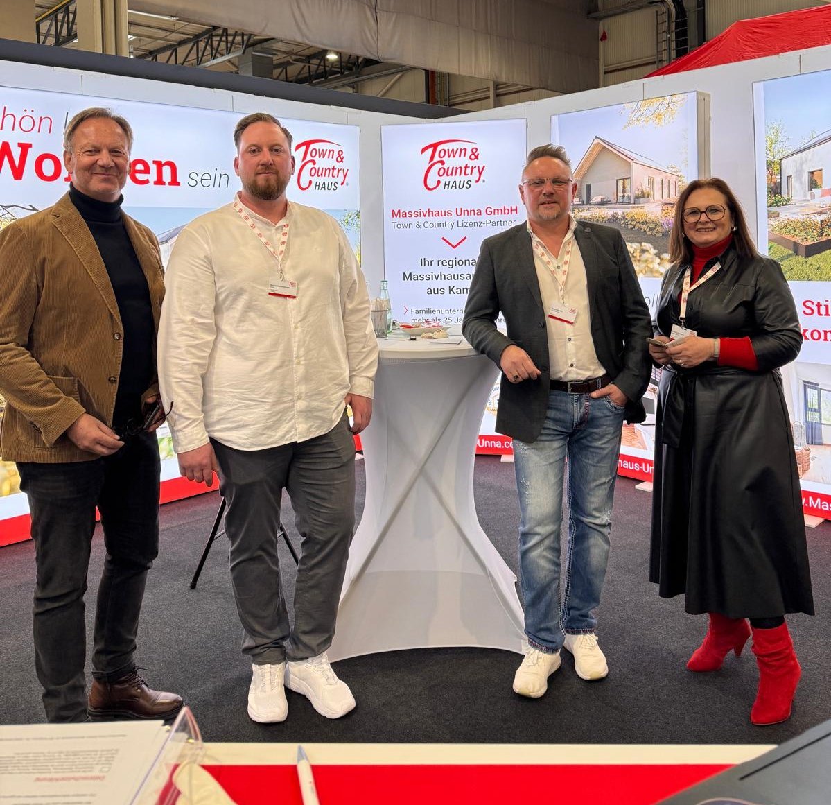 Team von Town & Country Haus Unna auf einer Baumesse: Lizenzpartner, Bauleiter, Hauskaufberater und Regionalleiter vor dem Messestand.