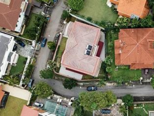 Luftaufnahme einer Straßenkurve mit Wohnhäusern, roten Dächern, Gärten und Bäumen in Kamen – Wohngebiet mit grüner Umgebung