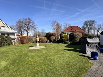 Grünes Baugrundstück in Erwitte mit gepflegtem Rasen und kleinen Bäumen und Sträuchern am Rand