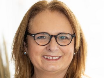 Porträt einer Hauskaufberaterin mit Brille – Fachfrau für Bauprojekte und Immobilienberatung