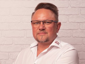 Hauskaufberater mit Brille – Porträtfoto eines erfahrenen Experten für Hausbau und Immobilien