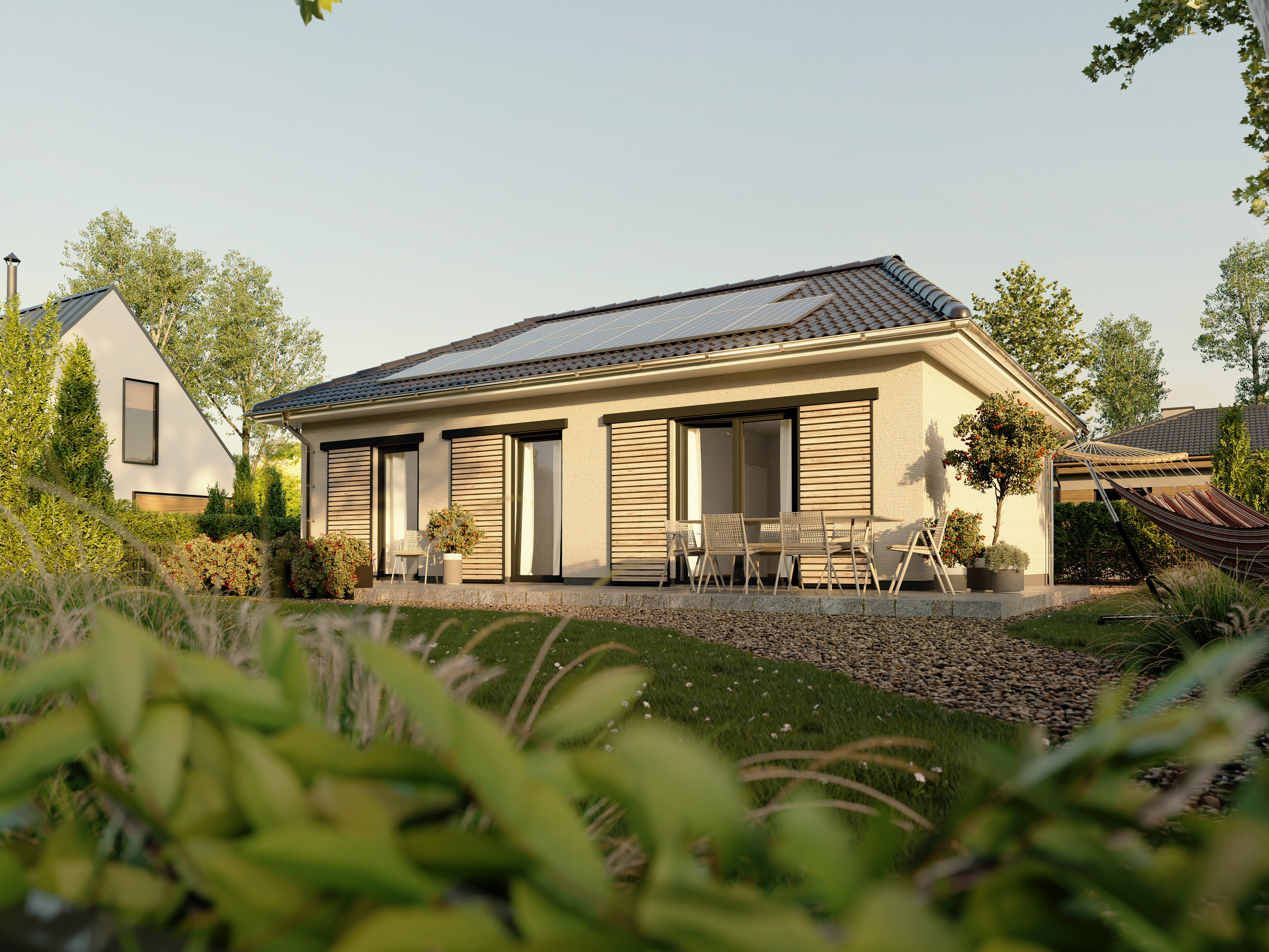 Ansicht des Bungalow 78 vom Garten aus mit einladender Terrasse und Photovoltaikanlage auf dem Dach für energieeffizientes Wohnen