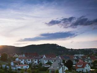 Vogelperspektiven Aufnahme von Wohnhäusern mit roten Dächern auf einer Anhöhe in Selm, umgeben von Grünflächen und unter blauem Himmel mit Wolken