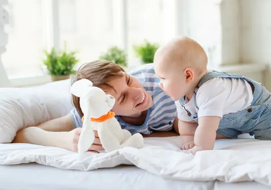 Familie-Hausbau-Orientieren-Informieren Vater und Sohn spielen auf dem Bett.